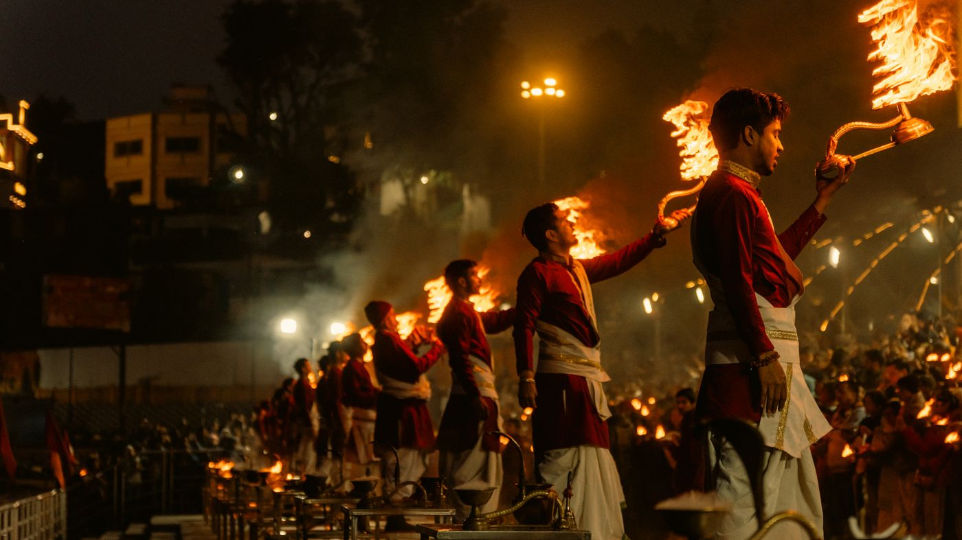 Priests performing a large Ganga Aarti ceremony with flaming lamps