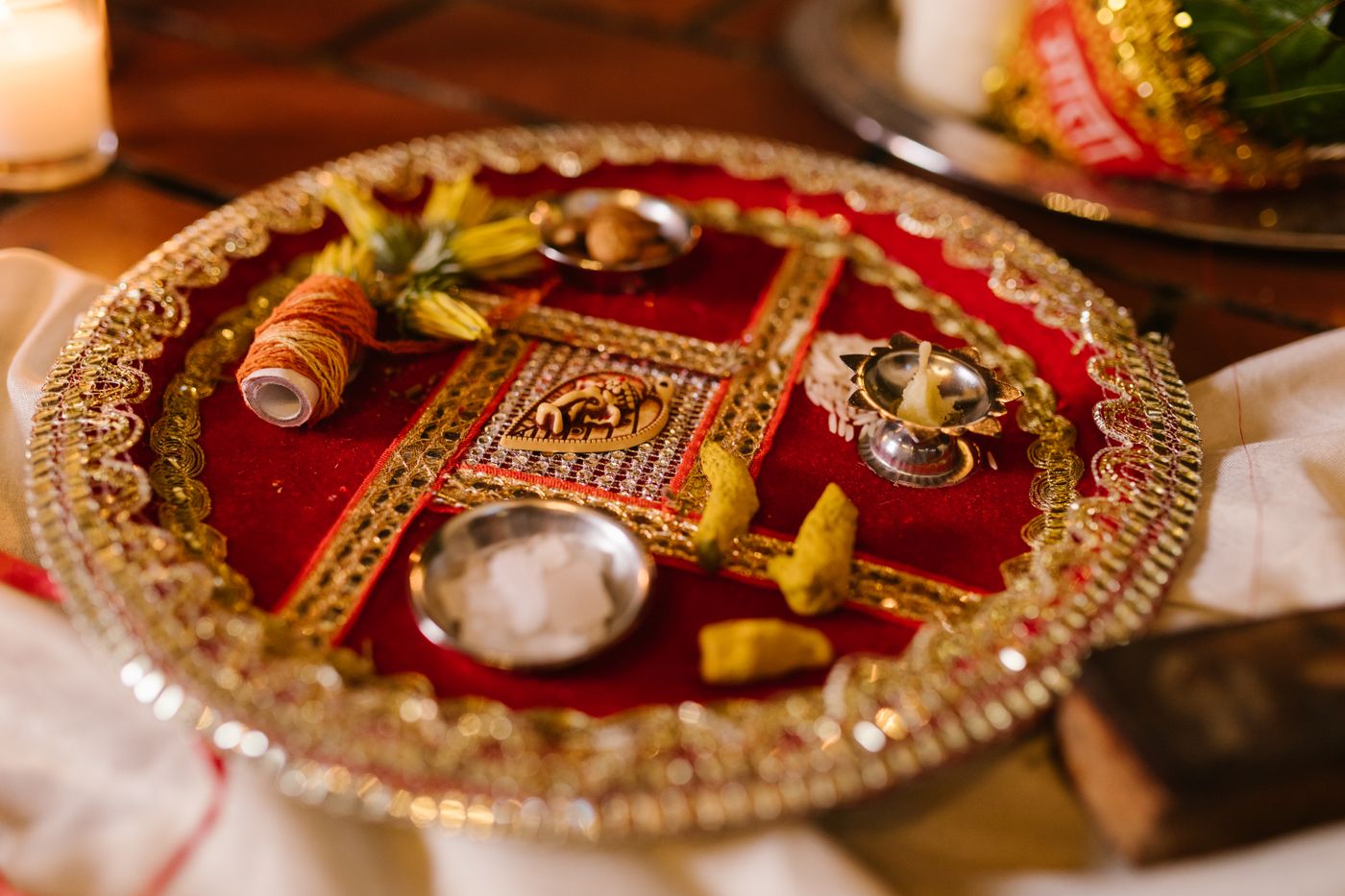 An ornate decorated puja thali with diya and offerings